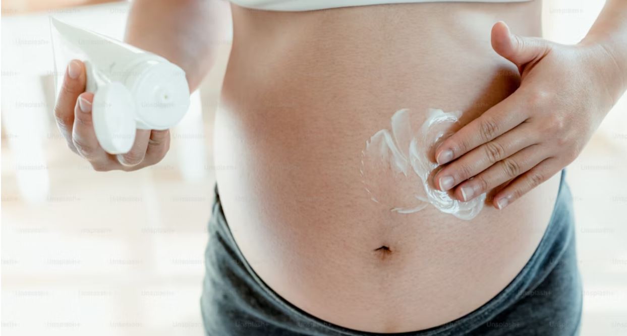 Pregnant Woman Applies Stretch Mark Cream
